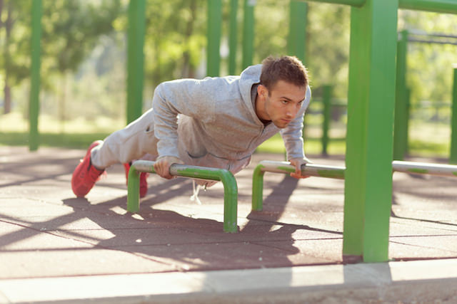 mann som gjør push ups fra stang